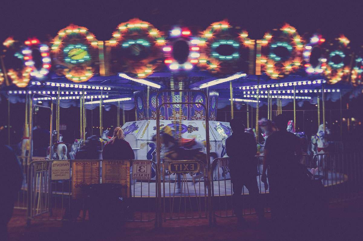 person people standing besides Merry-Go-Round during nighttime human